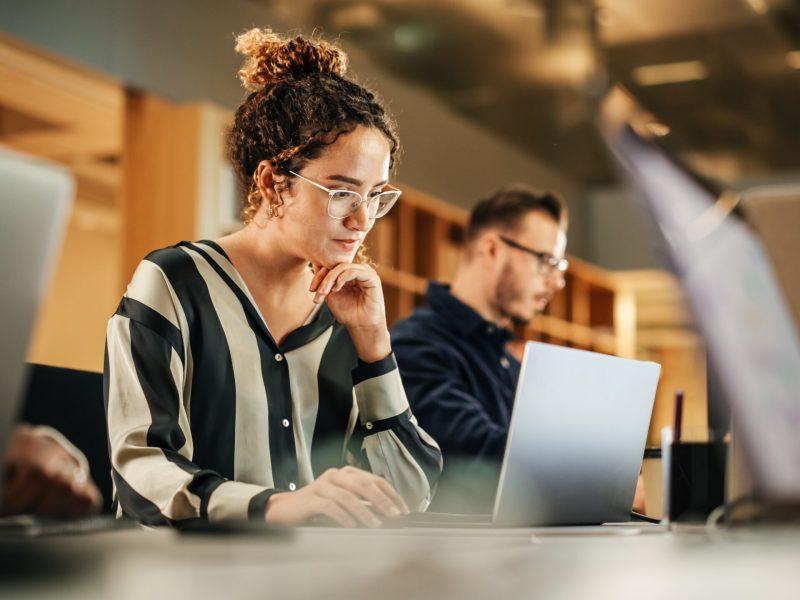 Portrait,Of,Enthusiastic,Hispanic,Young,Woman,Working,On,Computer,In